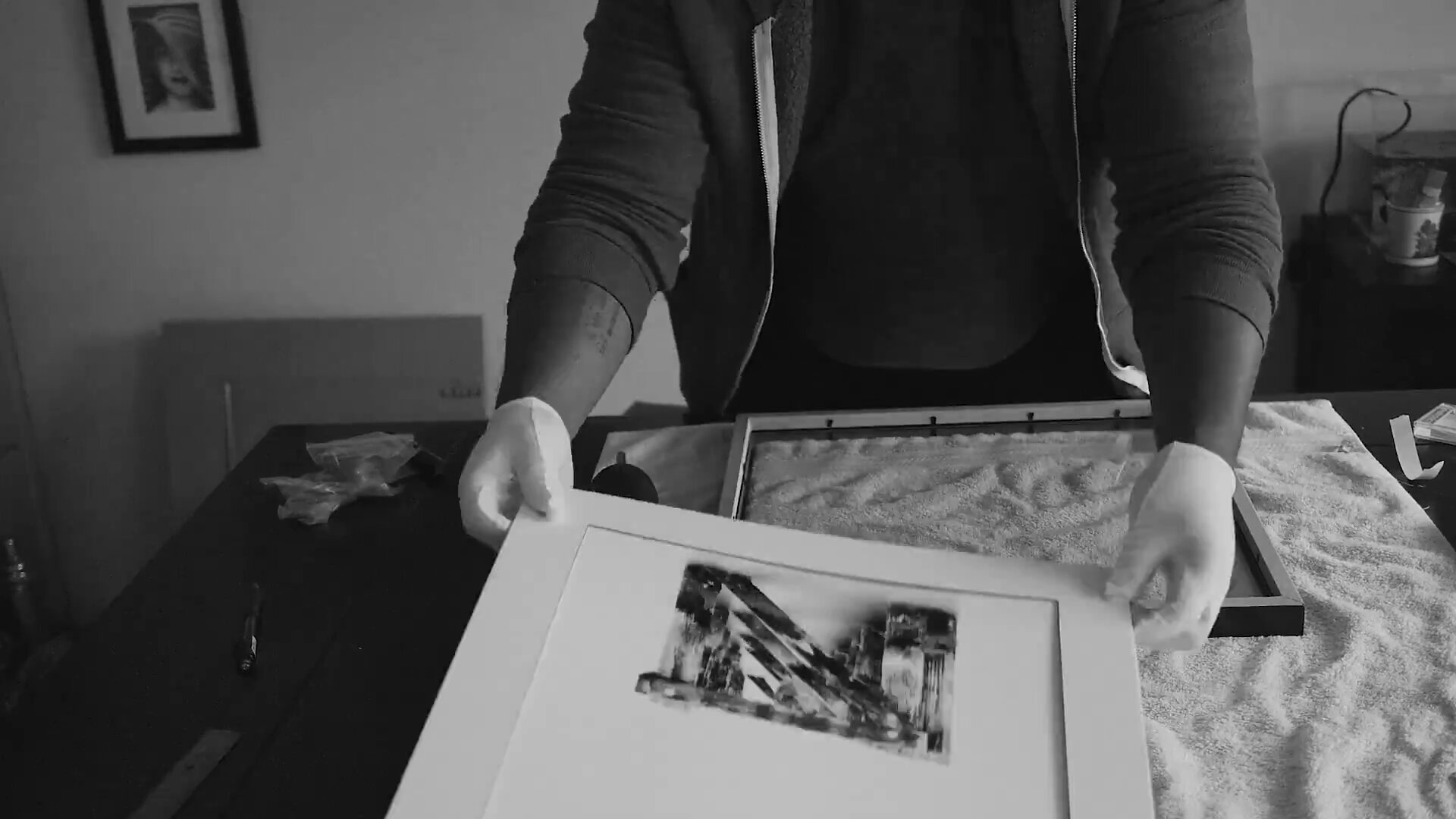 Kofi Amoa matting a hand-signed fine art print at the studio table